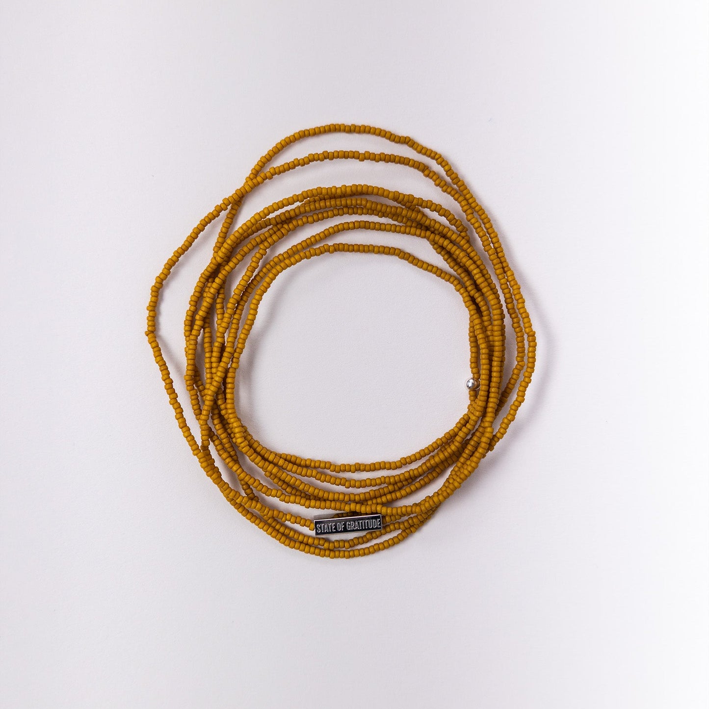 Coiled yellow bracelet on a white background