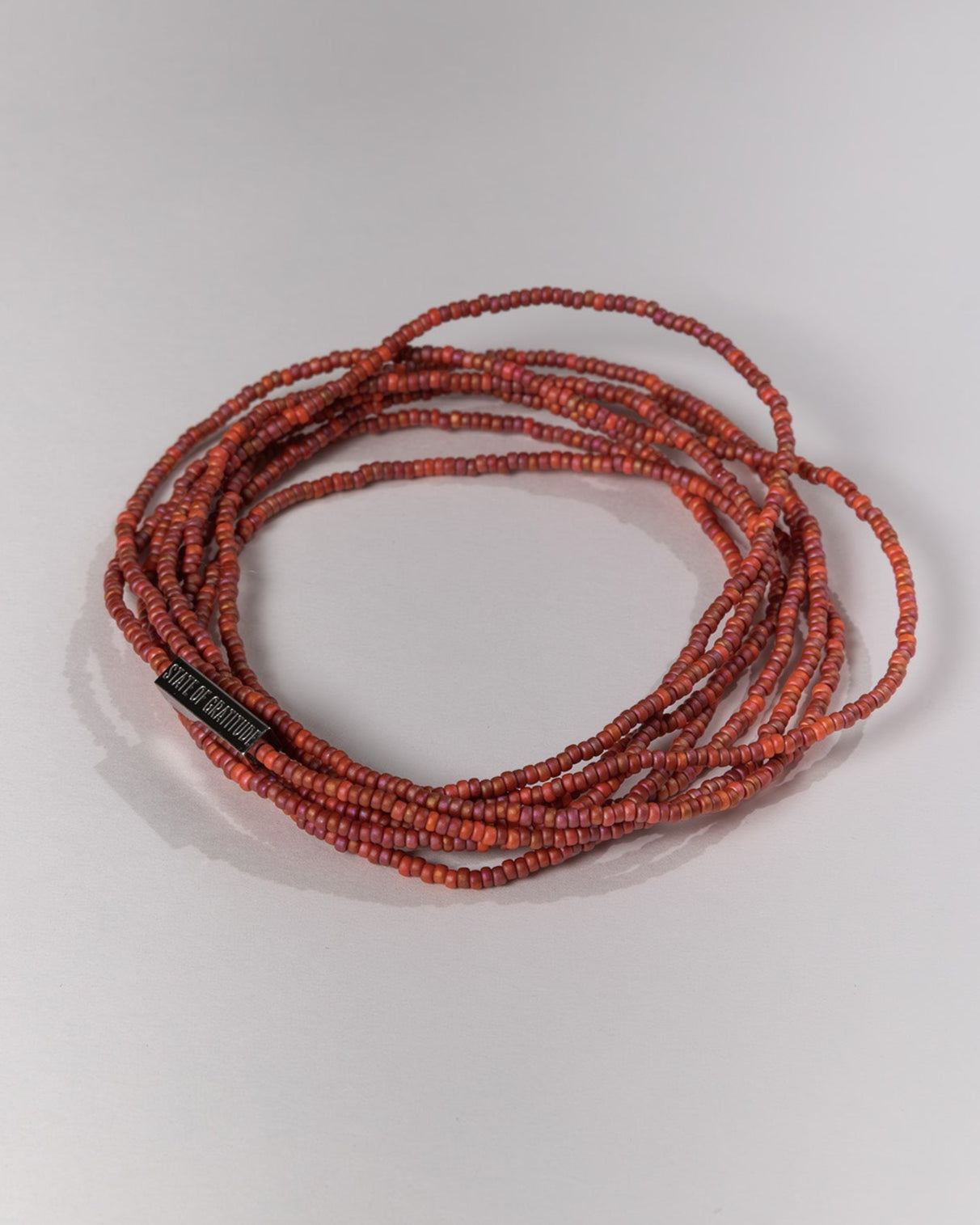 Red beaded necklace on a white background