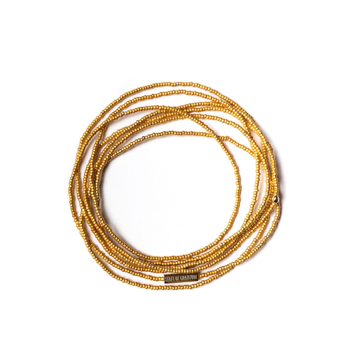 Gold beaded bracelets stacked on a white background