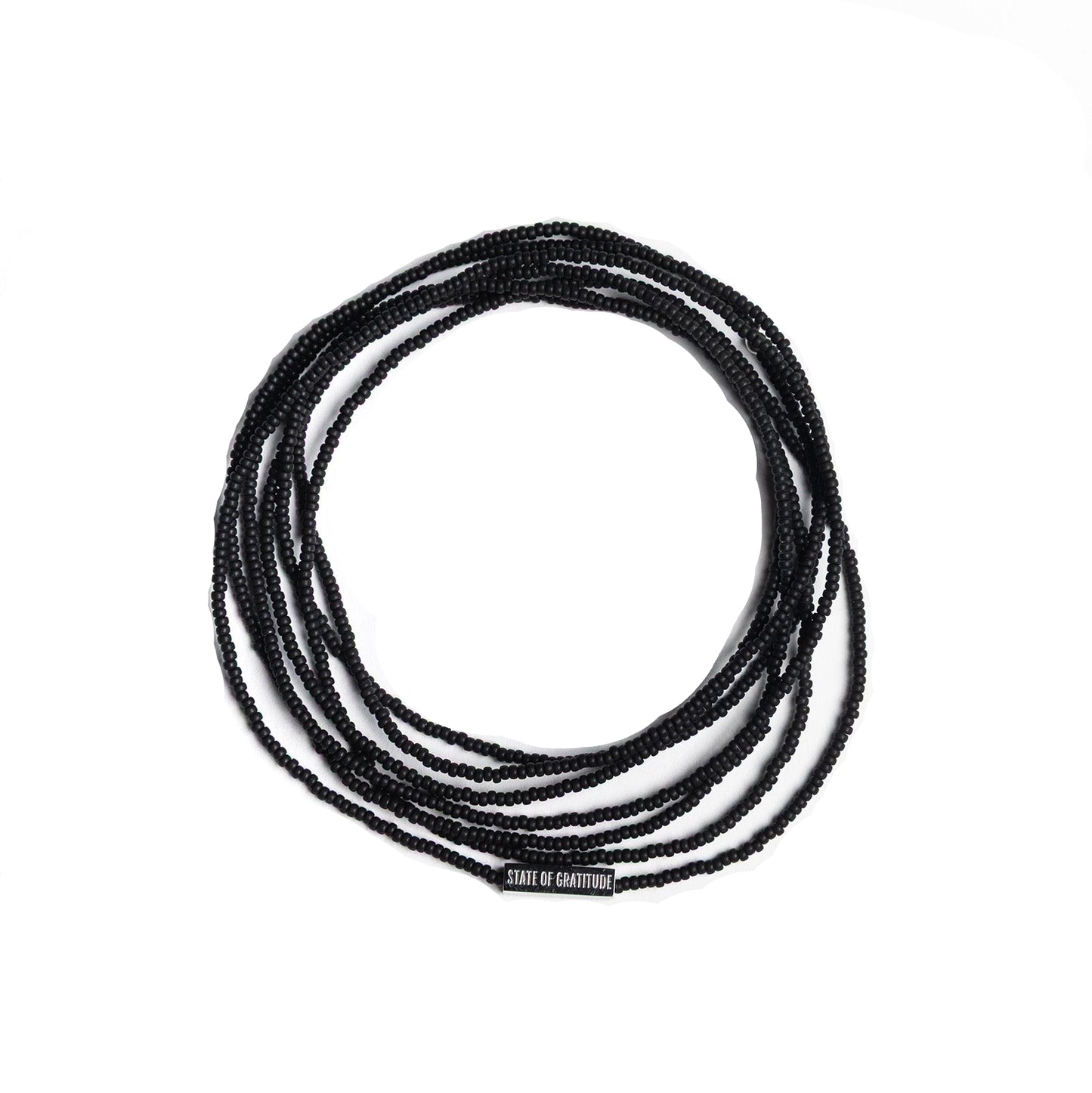 Black beaded bracelet wrap coiled on a white background with 'State of Gratitude' engraved bar charm.