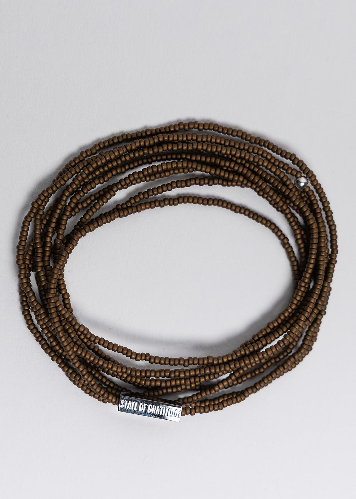 bronze beaded bracelet on a light gray background