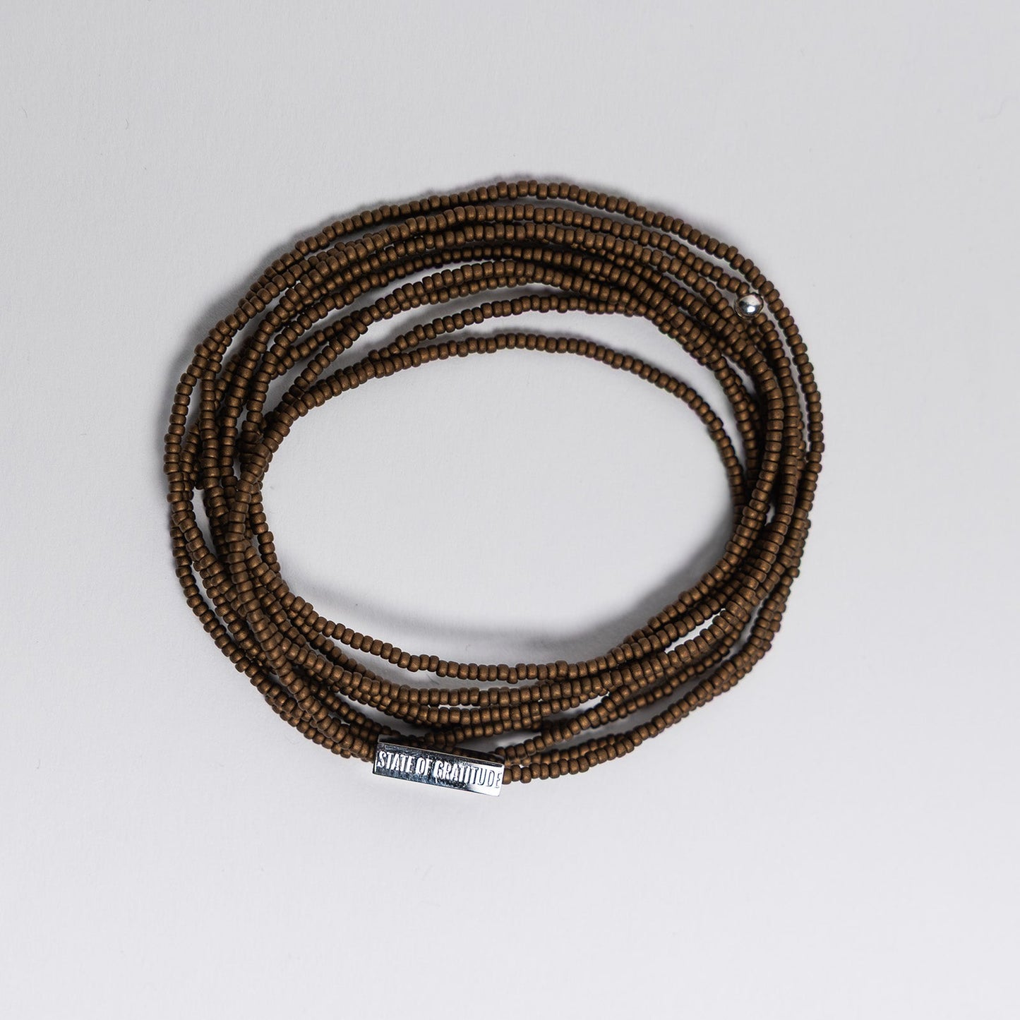 bronze beaded bracelet on a light gray background