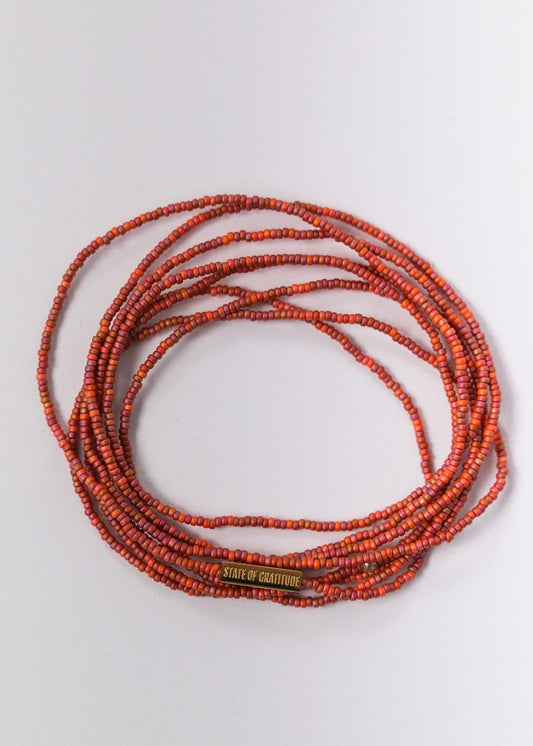 Pulsera de gratitud envuelta en rojo y naranja