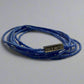 Blue beaded bracelet with a gold tag on a light gray background