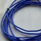 Close-up of blue beaded necklace on a light background
