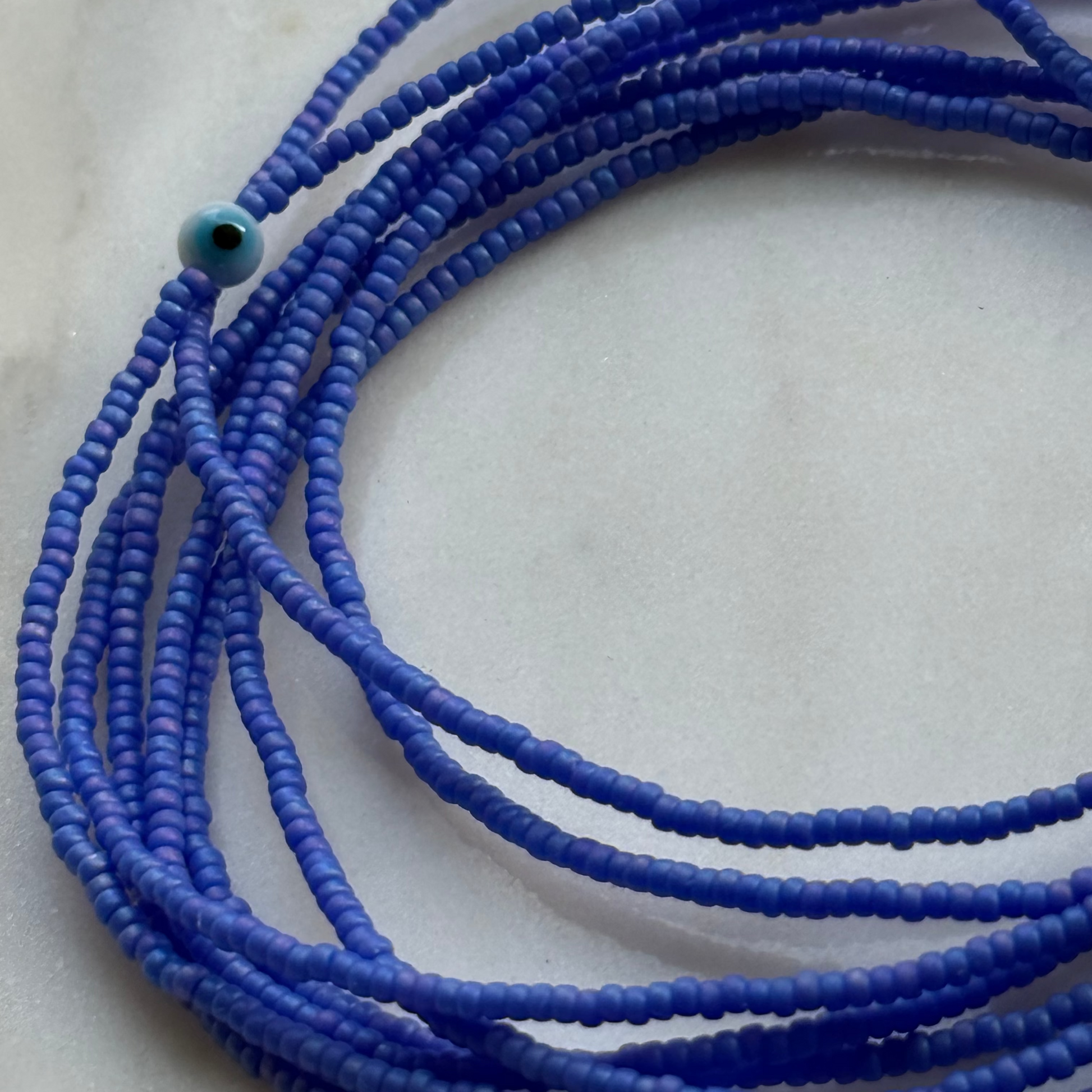 Close-up of blue beaded necklace on a light background