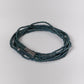 Blue beaded bracelet on a light gray background
