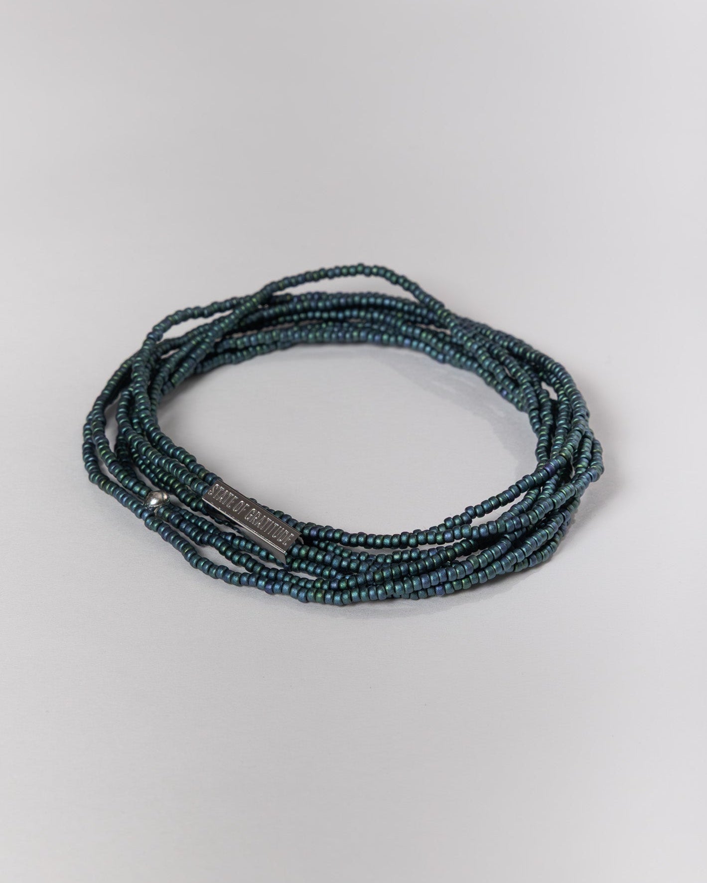 Blue beaded bracelet on a light gray background