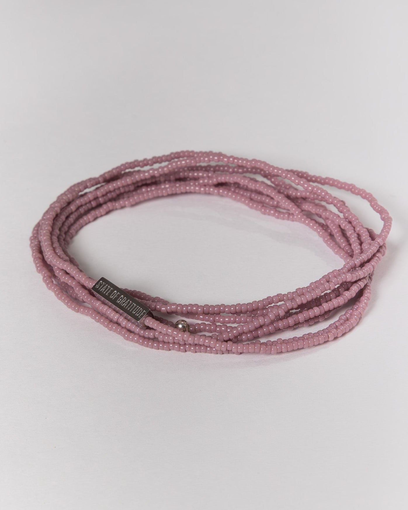 mauve beaded bracelet on a light gray background