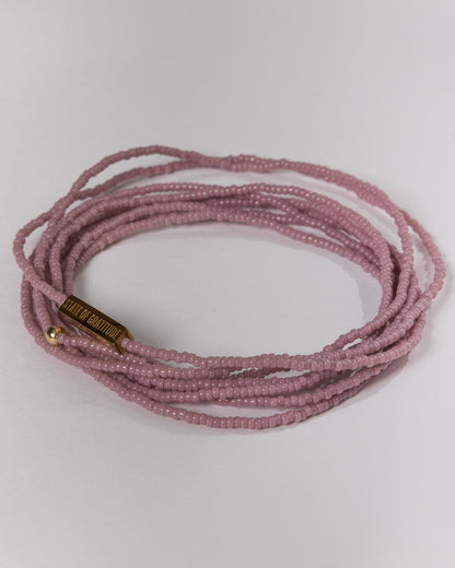 mauve beaded bracelet on a white background