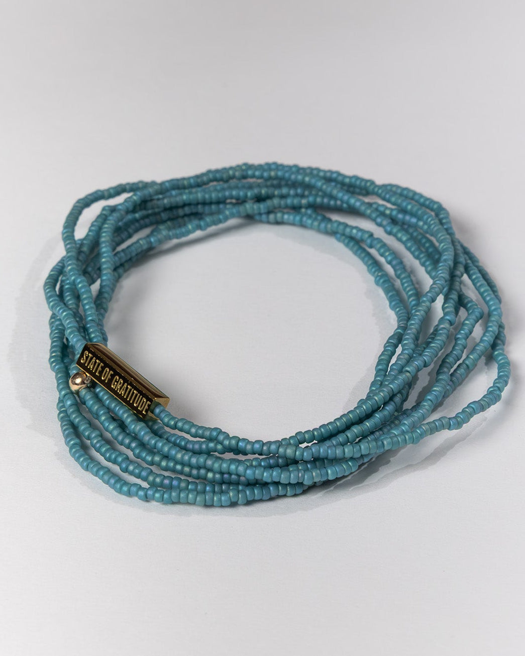 nile blue beaded bracelet on a light gray background