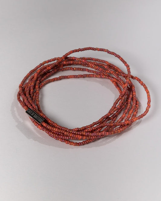 Red beaded necklace on a white background