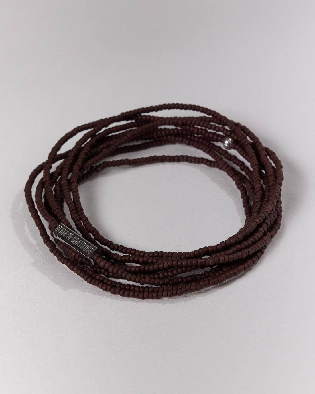 Brown beaded bracelet on a light gray background