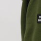 Green sweatshirt with 'STATE OF GRATITUDE' patch on a light gray background