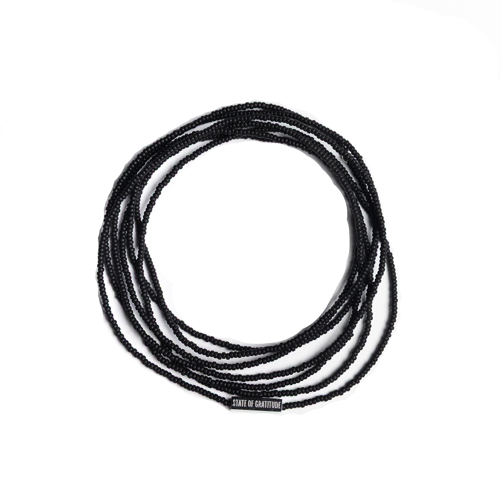 Black beaded bracelet wrap coiled on a white background with 'State of Gratitude' engraved bar charm.