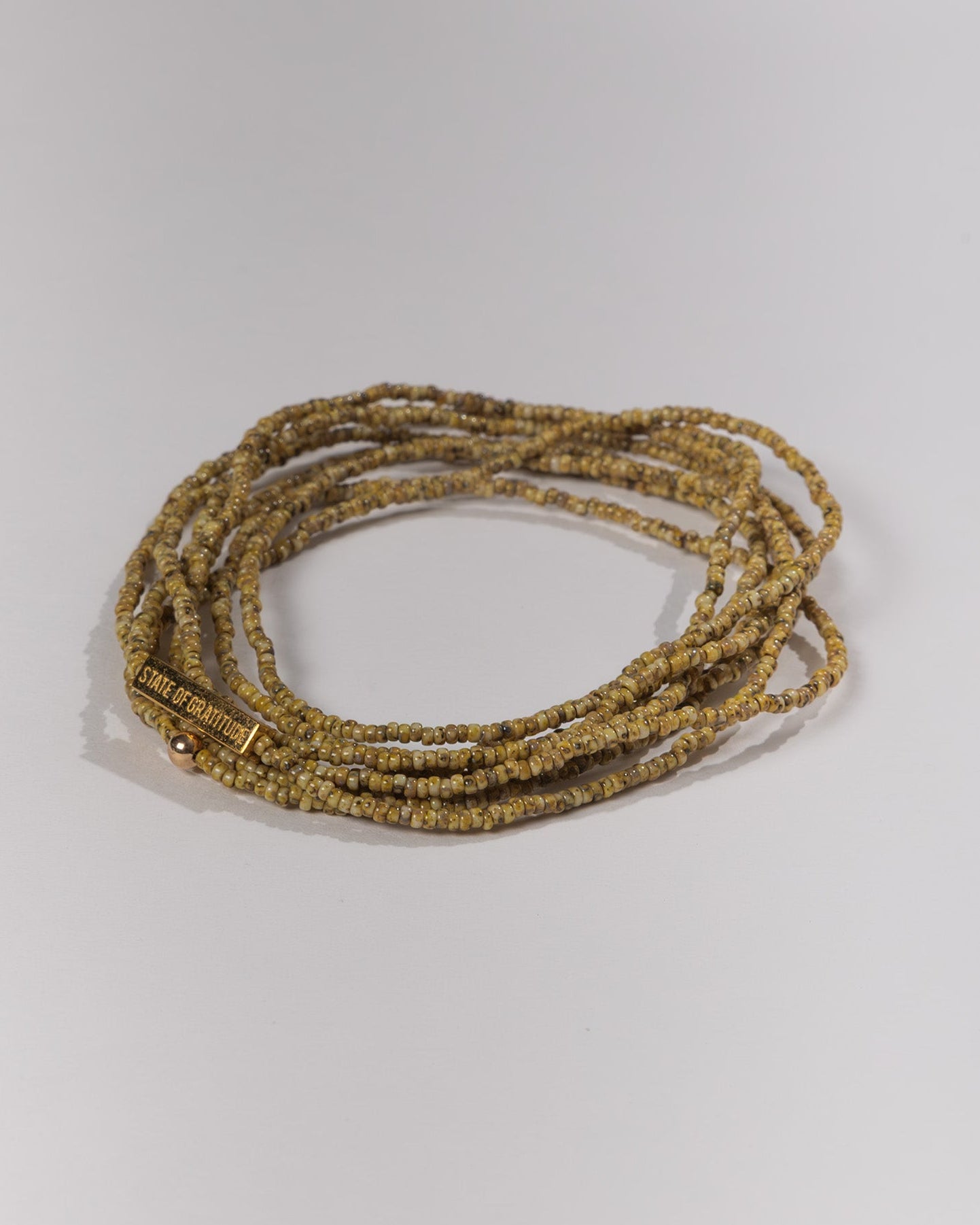 Set of gold beaded bracelets on a white background