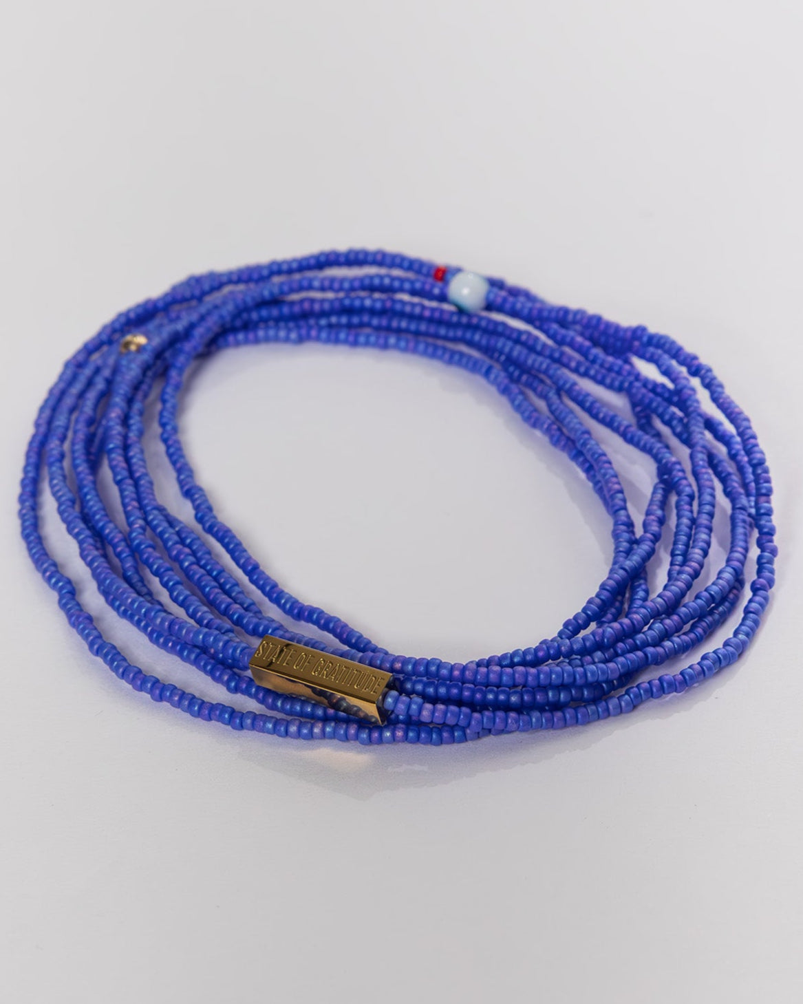 Blue beaded bracelet on a light gray background