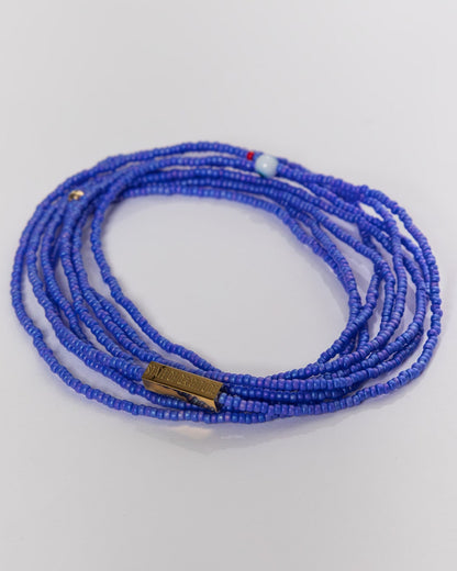 Blue beaded bracelet on a light gray background