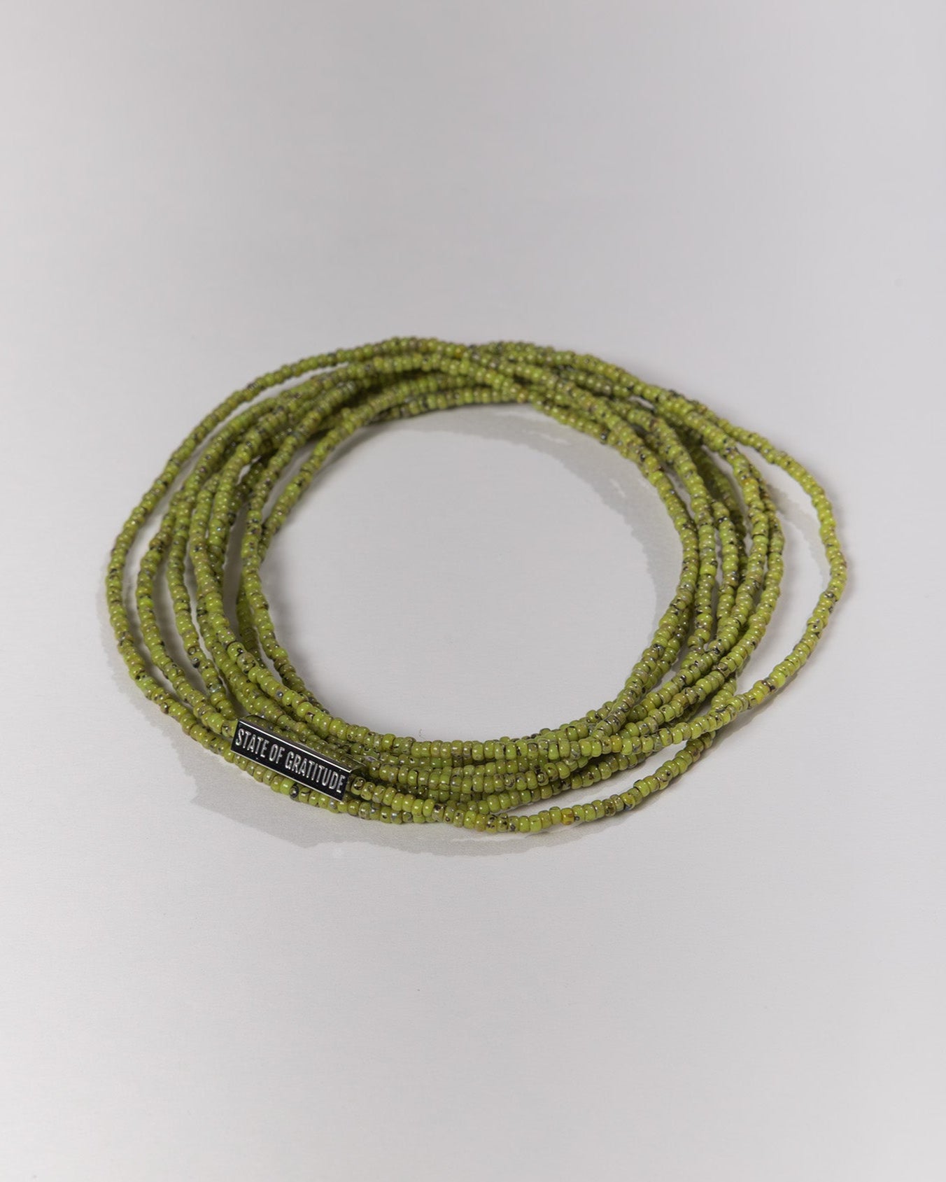 Green beaded bracelet with a label on a white background