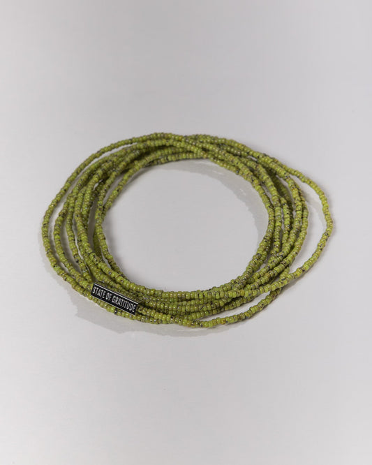 Green beaded bracelet with a label on a white background
