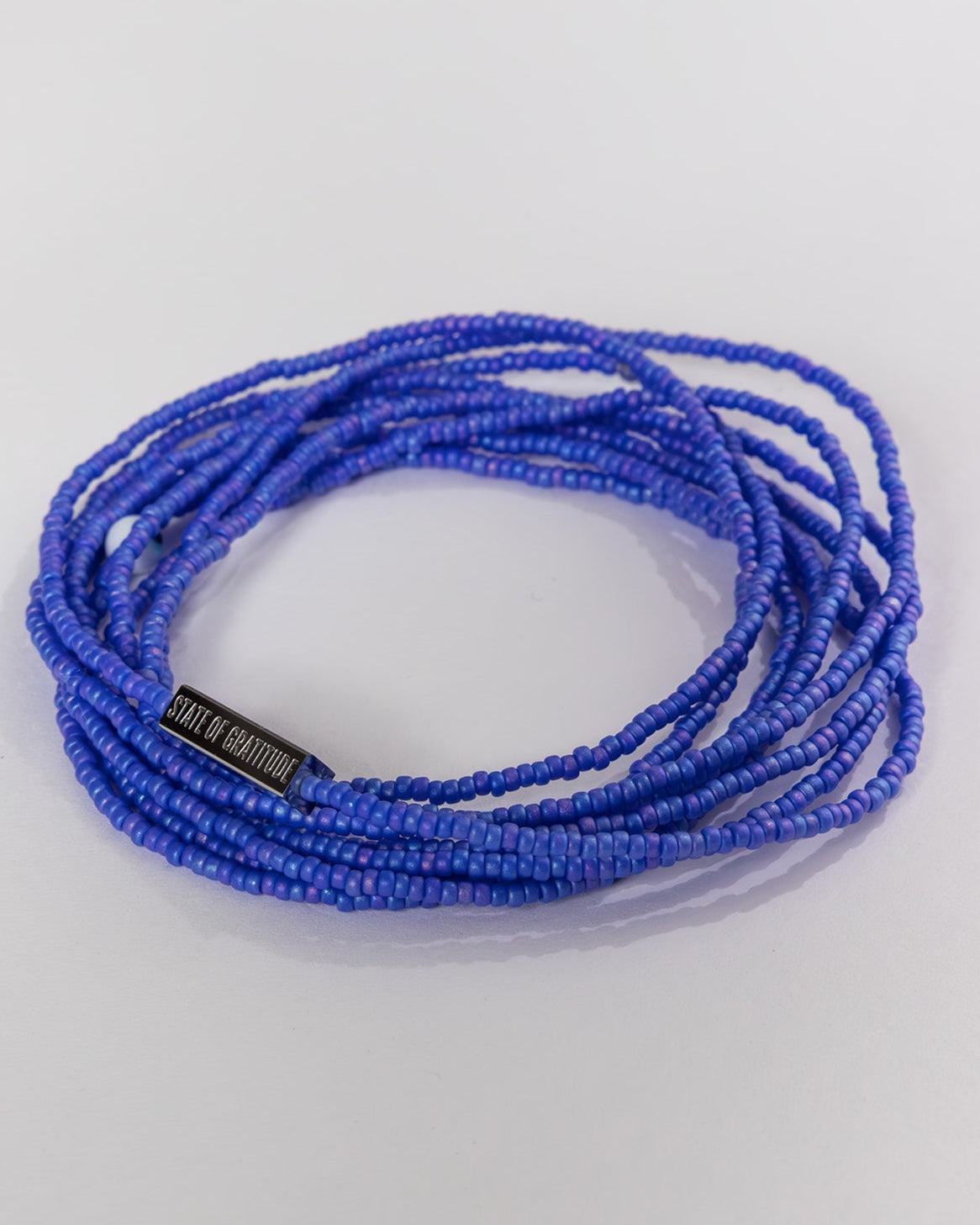 Blue beaded bracelet on a light gray background