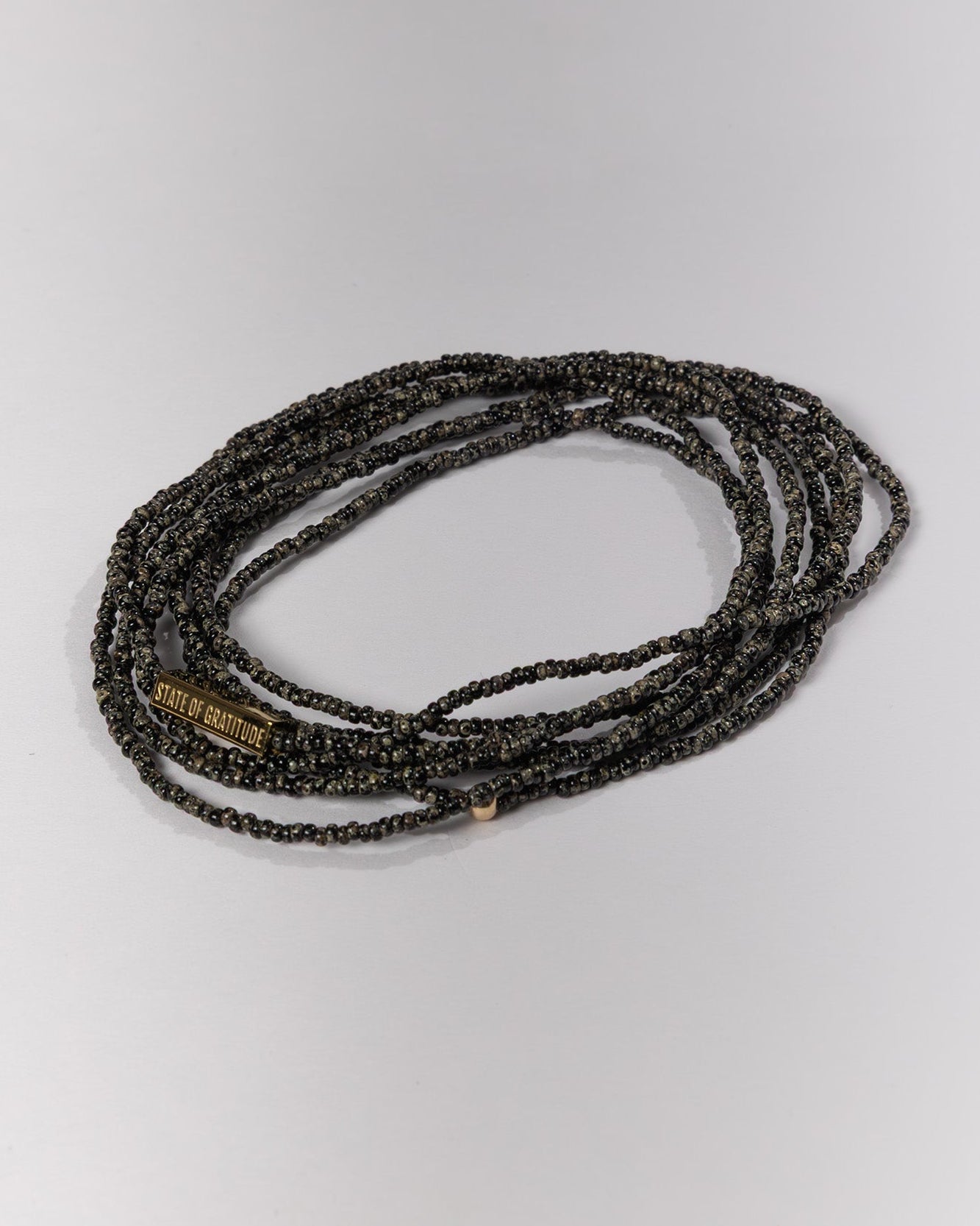 Black beaded wrap bracelet on a light gray background