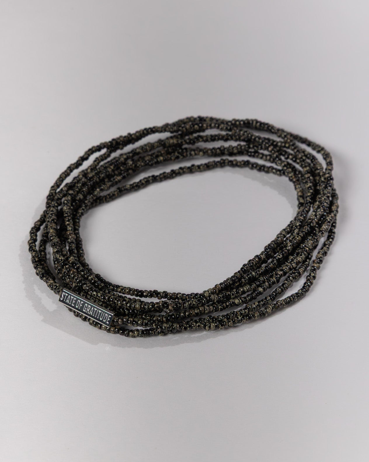 Black beaded bracelet on a light gray background