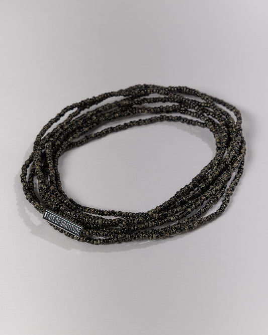 Black beaded bracelet on a light gray background