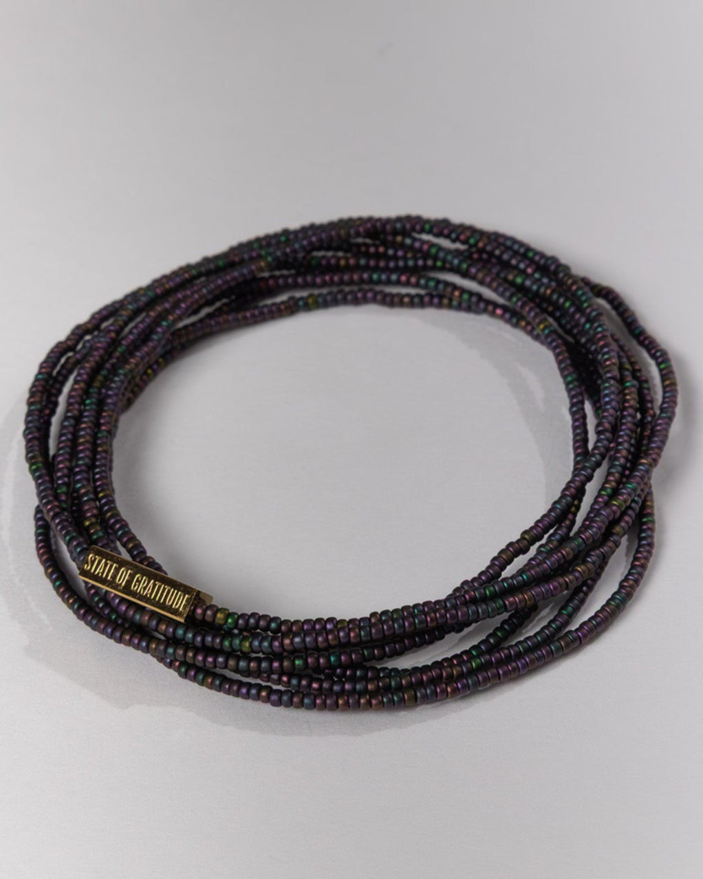 Multistrand beaded bracelet with a brand name on a light gray background