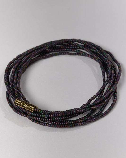 Multistrand beaded bracelet with a brand name on a light gray background